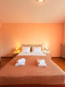 a bedroom with a large bed with two towels on it at Mega Panorama Apartments in Paleo Tsifliki
