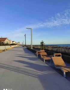 a row of benches on a sidewalk near the beach at Jolie studio Saint CYPRIEN 100m de la plage commerce et animation in Saint-Cyprien