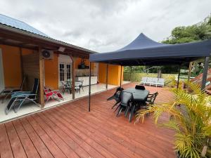 a deck with a blue umbrella on a house at La suite Corossol in Gros-Morne