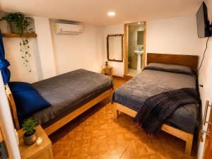 a bedroom with two beds and a mirror at Hotel Mirador Creel in Creel