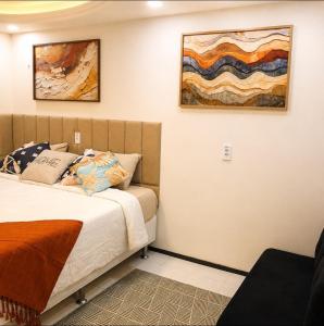 a bedroom with a bed and a painting on the wall at Quarto triplo em Petrópolis in Natal +31 photos