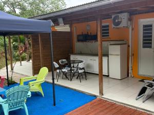 a patio with a kitchen and a table and chairs at La suite Corossol in Gros-Morne