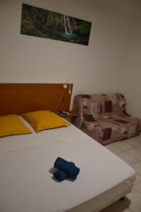 a bed with a pair of blue gloves sitting on it at La suite Corossol in Gros-Morne +18 photos