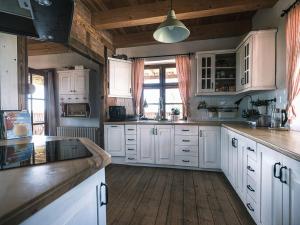 a kitchen with white cabinets and a wooden floor at Camping Szelągówka in Sorkwity