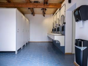 a locker room with blue tile floors and white cabinets at Camping Szelągówka in Sorkwity