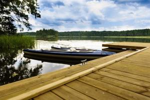 two boats are docked at a dock on a lake at Camping Szelągówka in Sorkwity