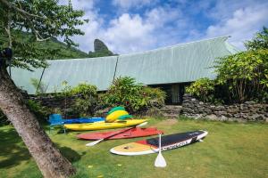 a group of surfboards sitting on the grass in front of a building at Fare Maeva in Paopao