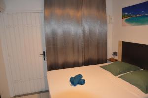 a bedroom with a bed with a blue hat on it at L'évasion Maracuja in Gros-Morne