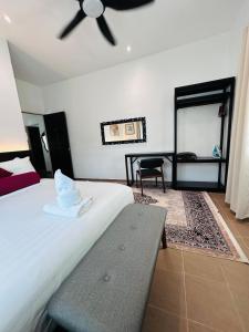 a bedroom with a bed with a ceiling fan at Rooma Kichi Private Pool in Pantai Cenang