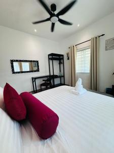 a bedroom with a large white bed with red pillows at Rooma Kichi Private Pool in Pantai Cenang +51 photos
