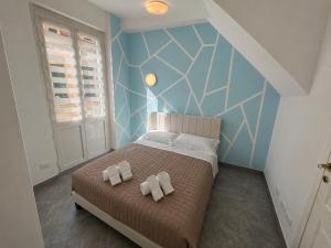 a bedroom with a bed with two towels on it at Alassio Attico con Terrazza AC WIFI in Alassio