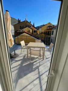 a patio with a table and chairs on a balcony at Alassio Attico con Terrazza AC WIFI in Alassio