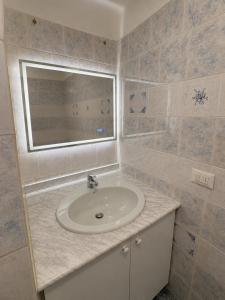 a bathroom with a sink and a mirror at Alassio Attico con Terrazza AC WIFI in Alassio