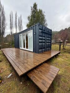 a black container sitting on top of a wooden deck at El Refugio Container in Futaleufú