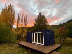 a tiny house sitting on top of a wooden platform at El Refugio Container in Futaleufú