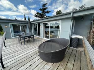 a wooden deck with a table and chairs on it at Maison bord de Seine à 20 min de Paris in Villennes-sur-Seine