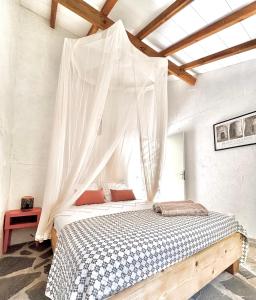 a bedroom with a bed with a mosquito net at Lodge Kara in Grand-Bourg