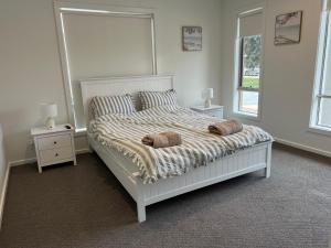 a white bed with two pillows on it in a bedroom at PONZ Lake Retreat - Nagambie in Nagambie +41 photos