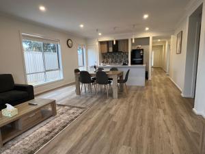 a living room and kitchen with a table and chairs at PONZ Lake Retreat - Nagambie in Nagambie