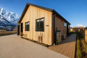 a wooden building with mountains in the background at Modern Mountain View Retreat, 2 Bedroom Stay in Frankton
