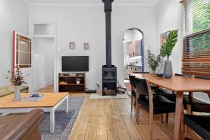 a living room with a table and a wood stove at Ada Art Deco by Host Solutions Hutt St, Heritage in Adelaide
