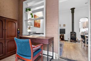 a home office with a desk and a blue chair at Ada Art Deco by Host Solutions Hutt St, Heritage in Adelaide