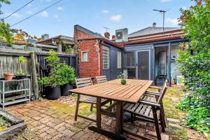 a patio with a wooden table and chairs at Ada Art Deco by Host Solutions Hutt St, Heritage in Adelaide