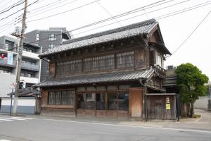 an old wooden building on the side of a street at 丹徳庭園 in Kawagoe