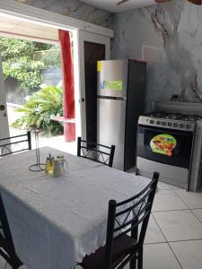 a kitchen with a table with a pizza on the oven at PuertoViejo in Puerto Viejo