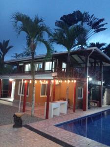 a house with palm trees next to a swimming pool at PuertoViejo in Puerto Viejo