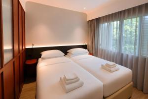 two beds in a room with white towels on them at Link Hotel Singapore in Singapore +22 photos