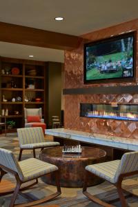 a living room filled with furniture and a tv at Courtyard by Marriott Lake George in Lake George