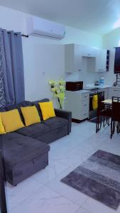 a living room with a couch and a kitchen at Escape casa Ja in Portmore