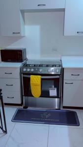 a kitchen with a stove with a yellow towel on it at Escape casa Ja in Portmore +16 photos
