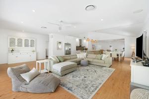 a living room with a couch and a table and a kitchen at Winders Beach House in Marcoola