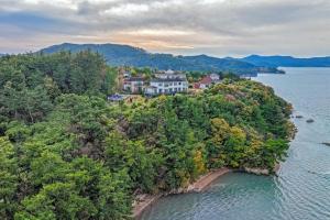 an aerial view of a house on an island in the water at Taean Napoli Pension in Seosan
