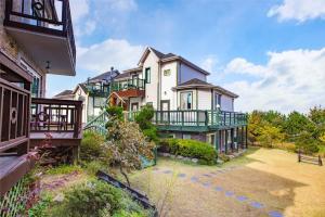 a large house with a balcony and a yard at Taean Napoli Pension in Seosan