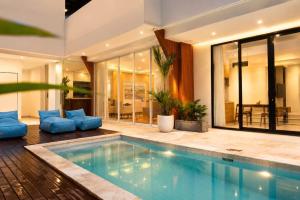 a swimming pool in a house with blue furniture at Hotel K Seminyak in Badung