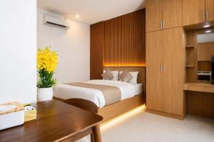 a bedroom with a bed and a desk and a table at Hotel K Seminyak in Badung