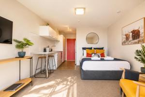 a bedroom with a large bed and a kitchen at Lake & Mountain Views, Close to Shops & Dining in Queenstown