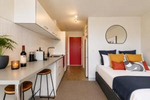 a bedroom with a bed and a kitchen at Lake & Mountain Views, Close to Shops & Dining in Queenstown