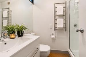 a bathroom with a sink and a toilet and a shower at Lake & Mountain Views, Close to Shops & Dining in Queenstown