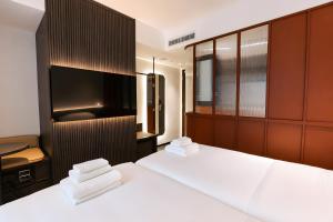 a bedroom with two beds and a flat screen tv at Link Hotel Singapore in Singapore