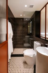 a bathroom with a toilet and a sink and a tub at Link Hotel Singapore in Singapore