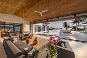 a living room with couches and a view of the ocean at Villa Amarelo in Ban Han Pa To