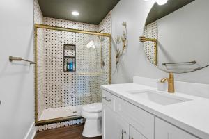a bathroom with a toilet and a sink and a mirror at The Bavarian Inn 6 Chic 1 BDR in Covington