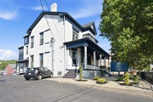 a white building with a car parked in front of it at The Bavarian Inn 6 Chic 1 BDR in Covington