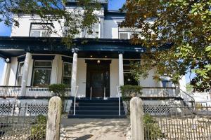 a white house with a black door and a fence at The Bavarian Inn 6 Chic 1 BDR in Covington +29 photos