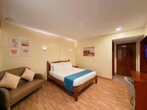 a bedroom with a bed and a couch at Rufana Suites in Moalboal