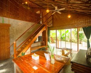 a living room with a wooden table and a staircase at Happiness Native Villa in El Nido